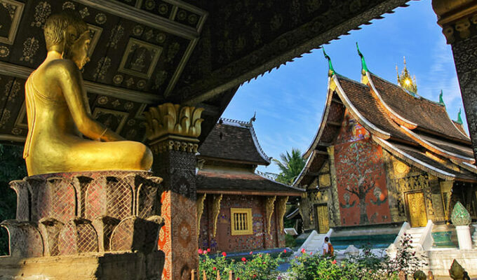 Buddha statue next to the sim of the Wat Xieng Thong, a Buddhist