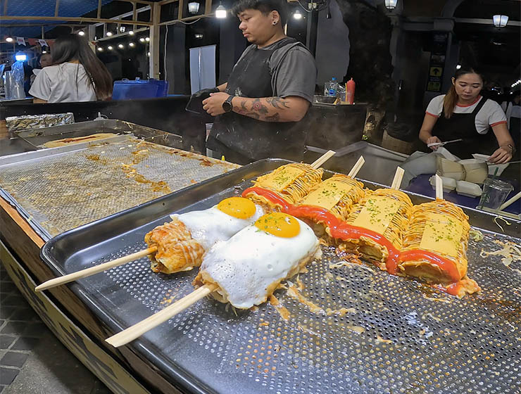 Hashimaki - okonomiyaki wrapped around chopsticks - at a food stall on Nimman Street Food Night Market; photo by Ivan Kralj.