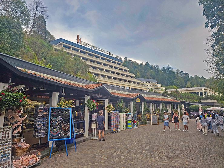 Exterior of the tiered architecture of Hotel Jama in Postojna, Slovenia, with promenade and shops in the front; photo by Ivan Kralj.