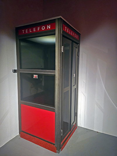 A vintage telephone booth installed in the corner of Hotel Jama's Secret Room, a passage to the Yugoslav-era surveillance center that operated within the hotel since the 1970s; photo by Ivan Kralj.