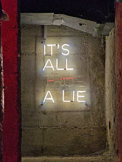 Neon sign switching between "It's all true" and "It's all a lie" in the backstage of Secret Rooms in Hotel Jama, Postojna, Slovenia; photo by Ivan Kralj.