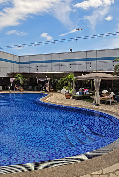 A plane flying over the swimming pool on the roof of Singapore Changi Airport's Terminal 1, part of Aerotel transit hotel; photo by Ivan Kralj.