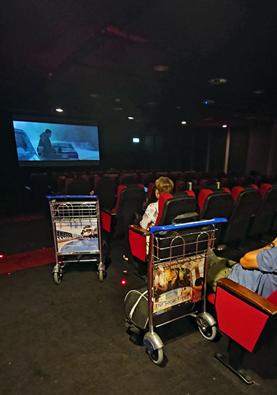 Airport trolleys parked in a cinema as passengers enjoy the film at Changi Airport Movie Theater, Terminal 3, Singapore Airport; photo by Ivan Kralj.