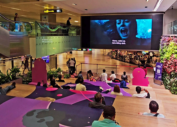 People watching a film at ST3PS, public-area movie theater at Changi Airport in Singapore, Terminal 3; photo by Ivan Kralj.